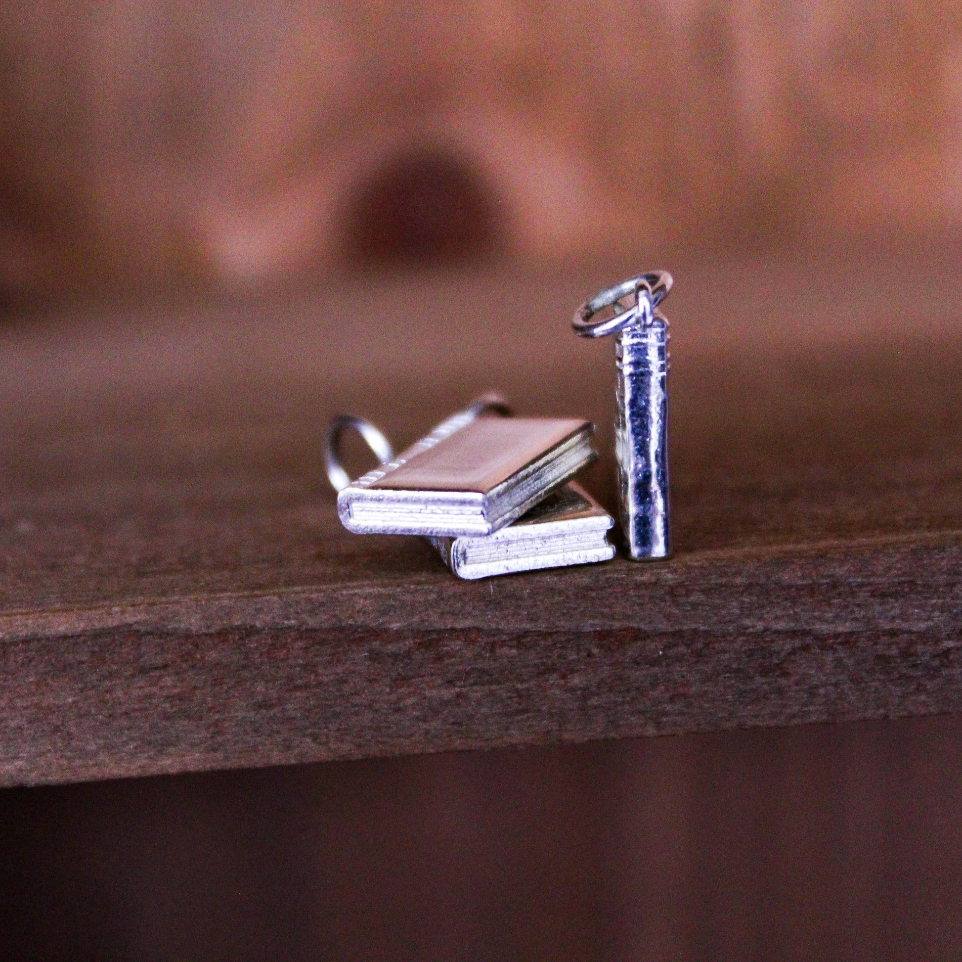 Silver book charms on a wooden surface