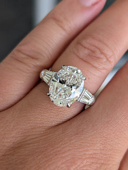 Platinum Three Stone Engagement Ring featuring a 5 carat Oval Center and .75ct Side Tapered Baguettes on a 3mm wide band.